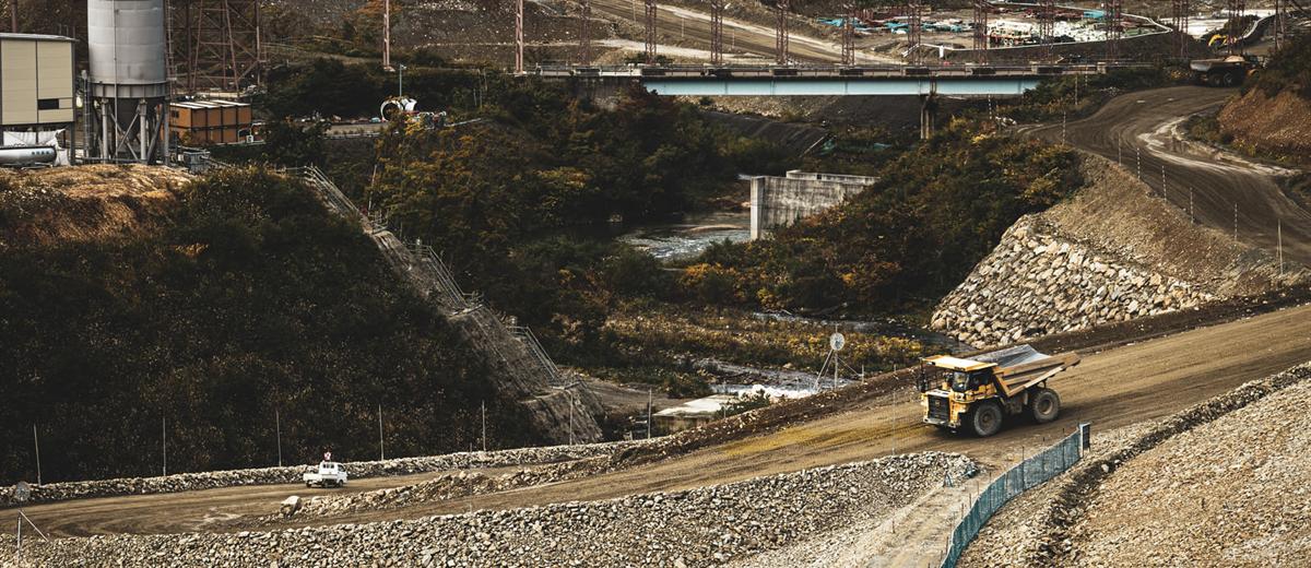 山間部のダム建設現場。造成された斜面をダンプトラックが走る