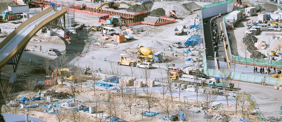 大阪の再開発工事現場を高所から見下ろした様子。重機と資材が広がる